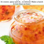 Ultra closeup vertical photo of a jar of Mango Jalapeño Pepper Jelly with fresh mint leaves in front of the jar and a graphic title at the top of the picture.